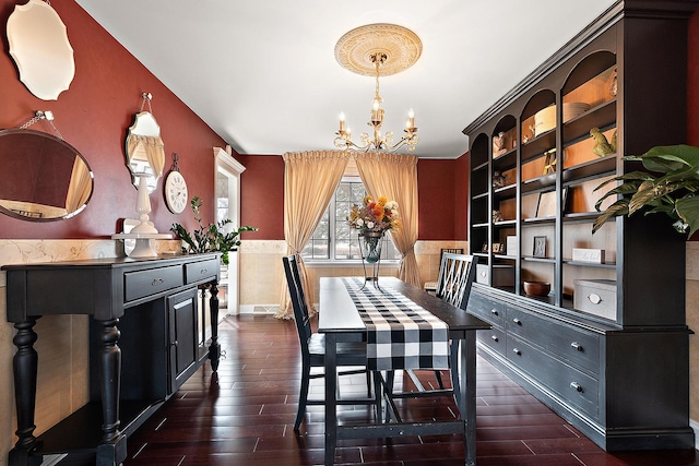 dining space featuring dark wood-style flooring and an inviting chandelier