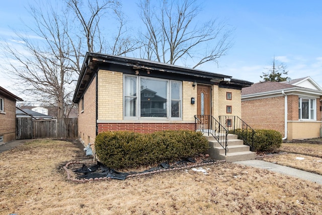 view of front of home featuring brick siding and fence