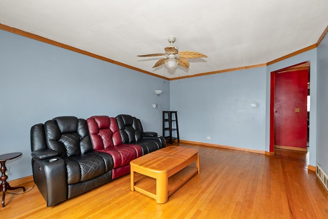 living area with ornamental molding, ceiling fan, baseboards, and wood finished floors