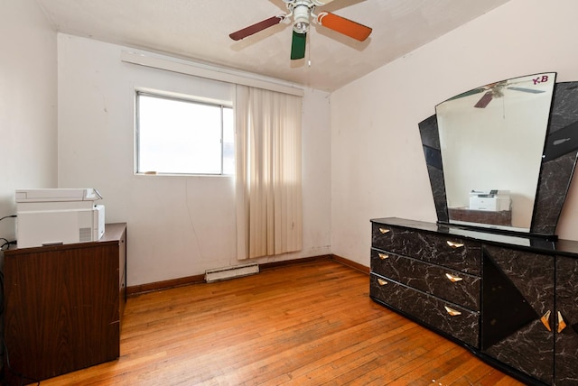 bedroom featuring baseboards, baseboard heating, a ceiling fan, and light wood-style floors