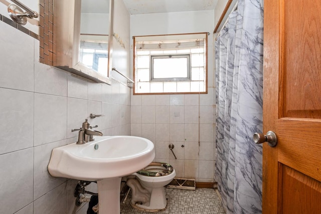 bathroom featuring toilet, curtained shower, visible vents, and tile walls