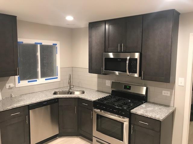 kitchen with recessed lighting, a sink, appliances with stainless steel finishes, light wood finished floors, and tasteful backsplash