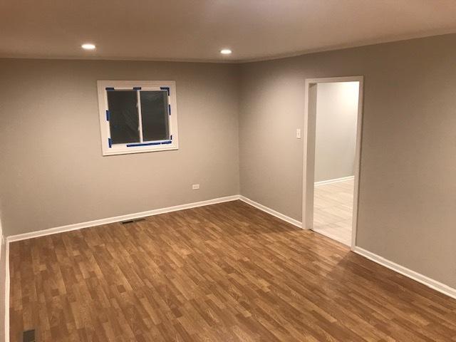 empty room with recessed lighting, wood finished floors, and baseboards