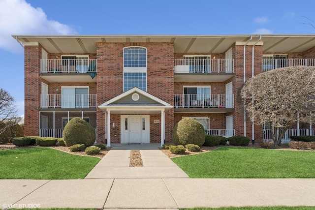 view of front facade with a front yard and brick siding