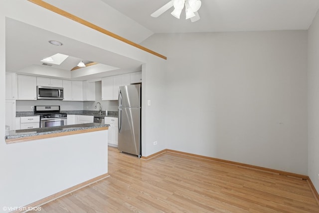 kitchen with white cabinetry, light wood-style floors, appliances with stainless steel finishes, and a sink