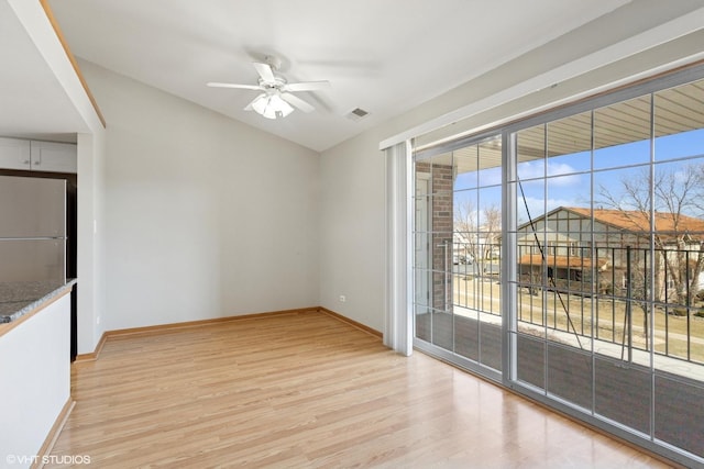 unfurnished room featuring light wood finished floors, visible vents, baseboards, and a ceiling fan