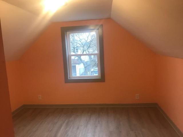 bonus room with lofted ceiling, wood finished floors, and baseboards