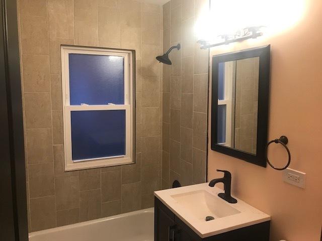 bathroom featuring washtub / shower combination and vanity