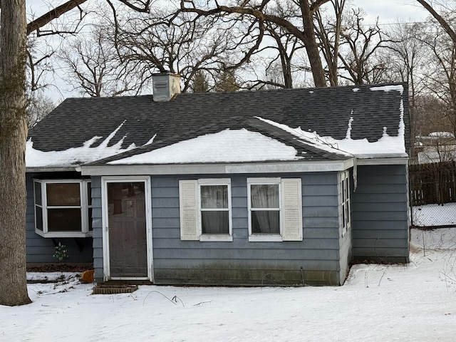 bungalow-style home featuring a shingled roof and a chimney