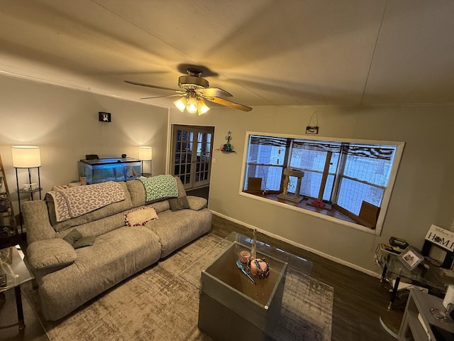 living area featuring wood finished floors, a ceiling fan, and baseboards