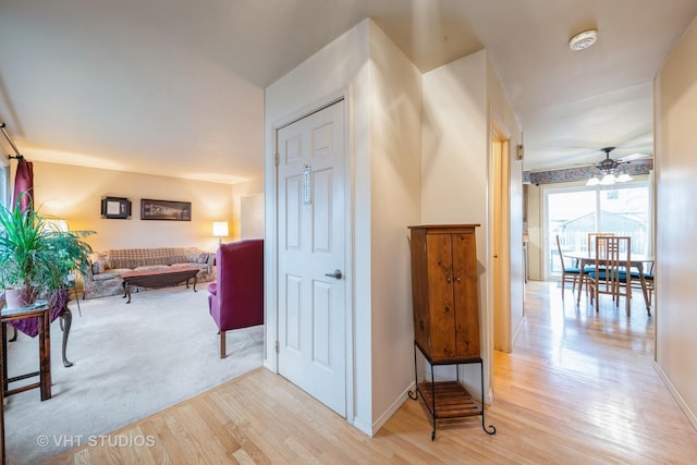 hall featuring light wood-type flooring and baseboards