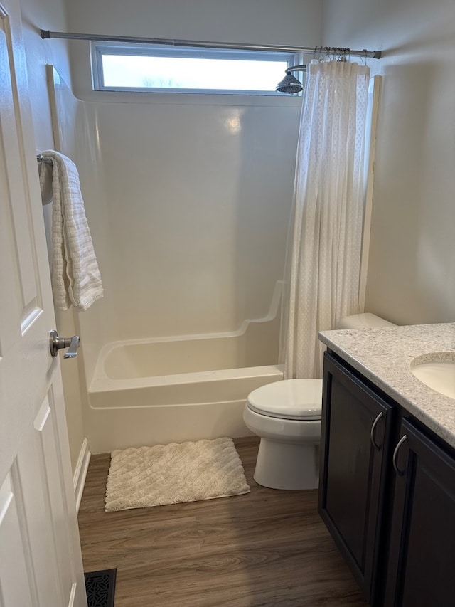 bathroom with visible vents, toilet, shower / tub combo, vanity, and wood finished floors