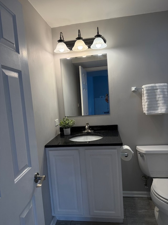 half bathroom with vanity, toilet, and baseboards