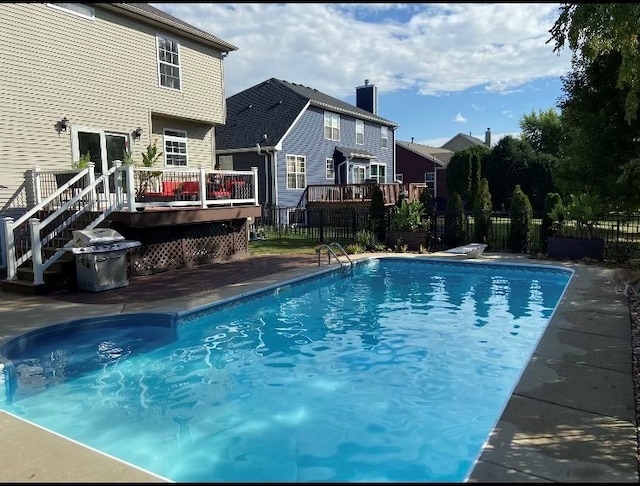 view of pool with a grill, fence, a wooden deck, a fenced in pool, and a patio area