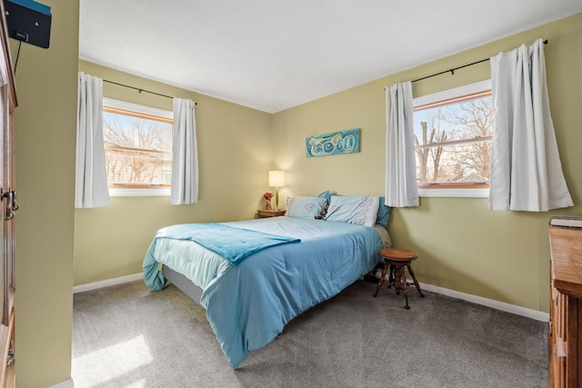 carpeted bedroom featuring multiple windows and baseboards