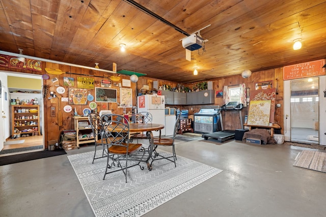 dining space with wood walls, concrete floors, and wood ceiling