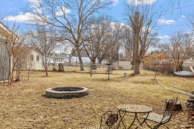 view of yard with fence and a fire pit