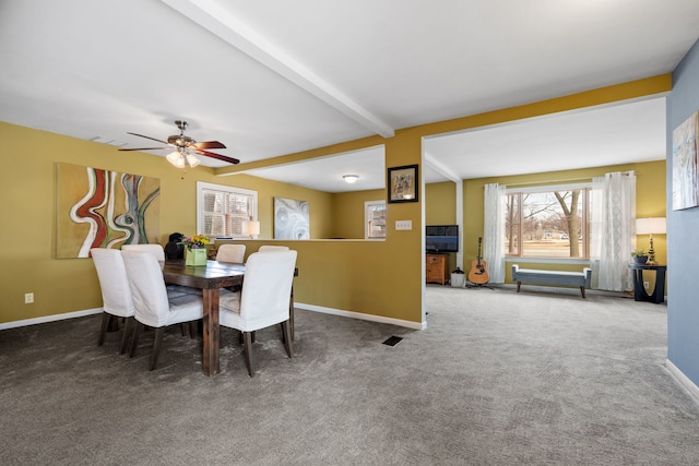 carpeted dining space with ceiling fan, beamed ceiling, and baseboards