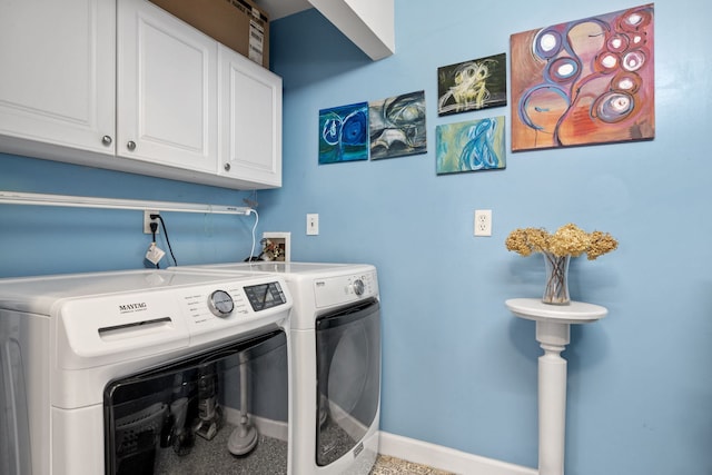 washroom featuring washing machine and dryer, cabinet space, and baseboards