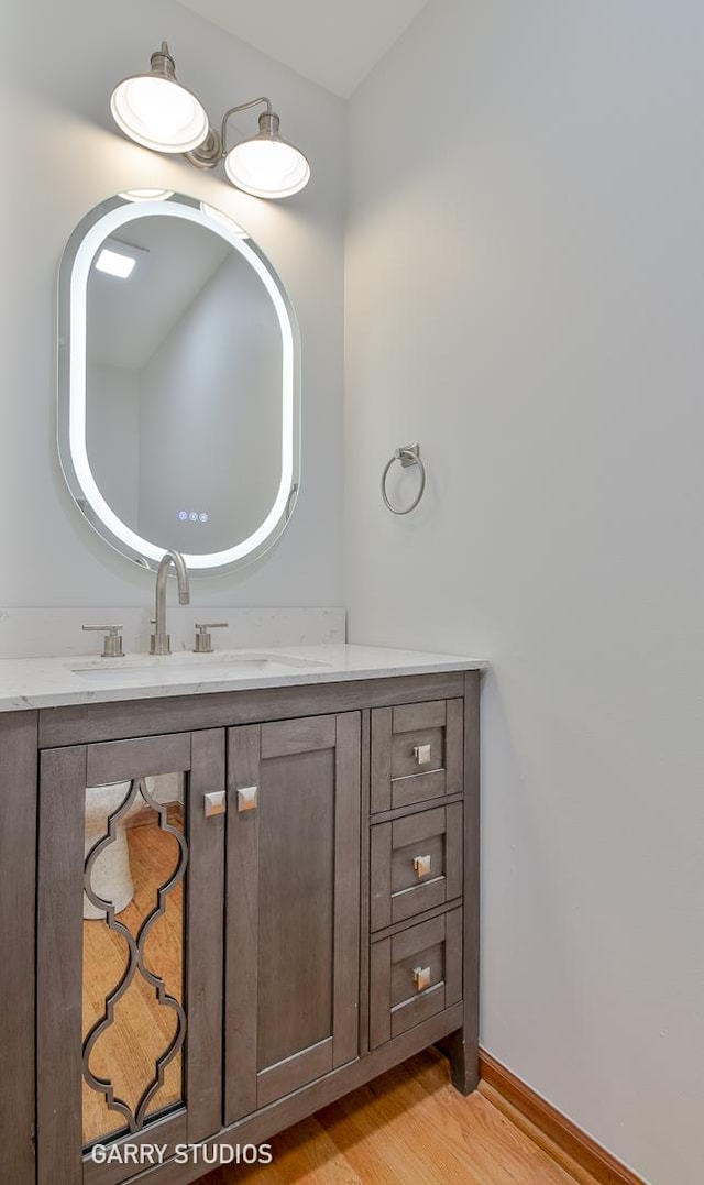 bathroom featuring wood finished floors, vanity, and baseboards