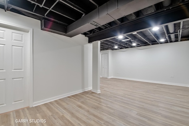 finished basement with baseboards and wood finished floors