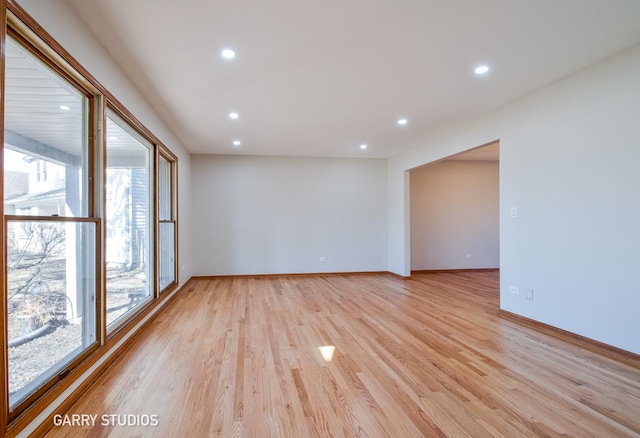 spare room featuring recessed lighting, light wood-type flooring, and baseboards