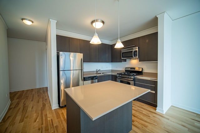 kitchen with a sink, light wood-style floors, stainless steel appliances, and dark brown cabinets