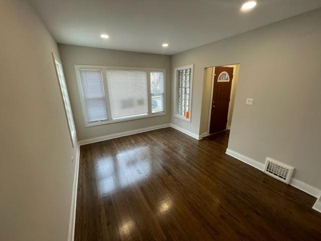 foyer entrance featuring dark wood-type flooring, recessed lighting, visible vents, and baseboards