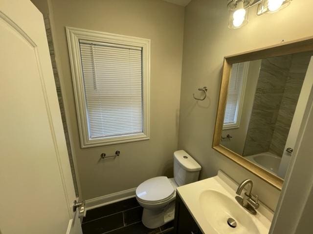 bathroom featuring toilet, tile patterned floors, vanity, and baseboards