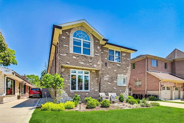 exterior space featuring a front yard, concrete driveway, and brick siding