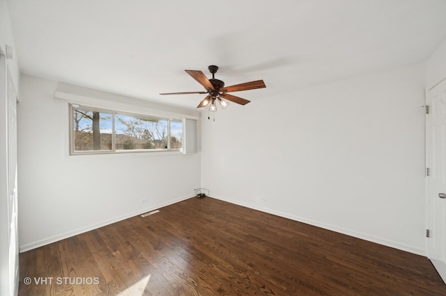 empty room featuring visible vents, baseboards, dark wood-type flooring, and a ceiling fan