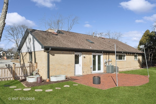 rear view of house with a patio area, a yard, fence, and brick siding