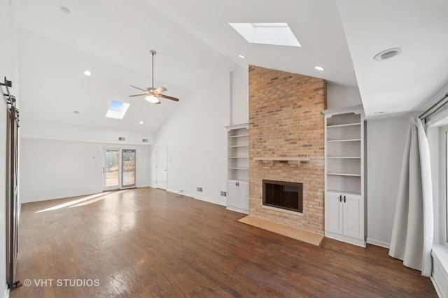 unfurnished living room with a fireplace, a skylight, wood finished floors, high vaulted ceiling, and a ceiling fan