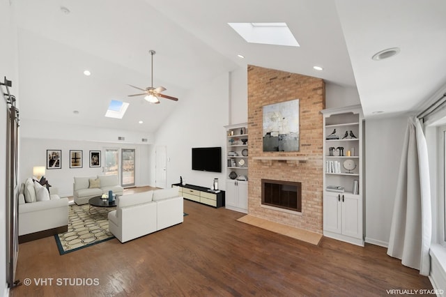 living room with high vaulted ceiling, a ceiling fan, a skylight, a brick fireplace, and dark wood-style floors