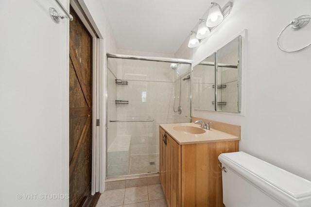 bathroom featuring tile patterned flooring, a shower stall, toilet, and vanity