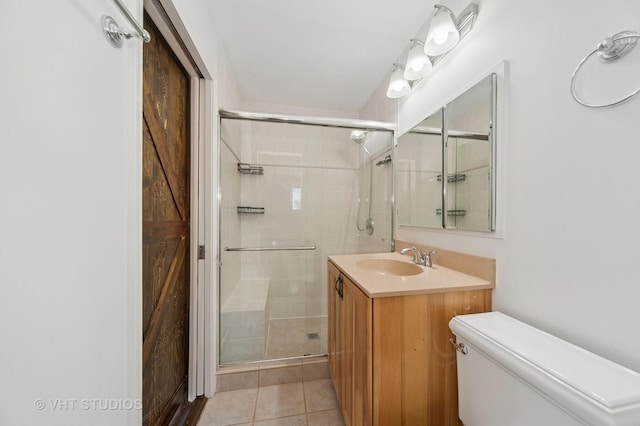 bathroom featuring tile patterned floors, toilet, a stall shower, and vanity