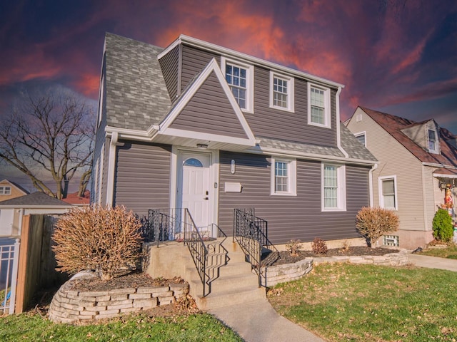 view of front of home with a front lawn and roof with shingles