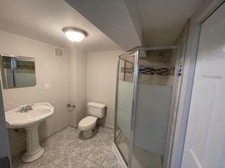 bathroom featuring a stall shower and toilet