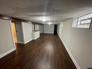 below grade area featuring baseboards and wood finished floors