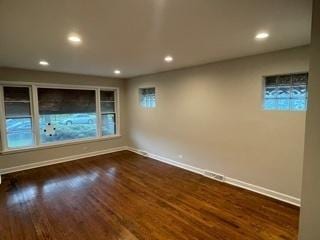 spare room with dark wood-type flooring, recessed lighting, and baseboards