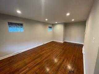 below grade area with dark wood-type flooring, recessed lighting, and baseboards