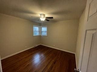 unfurnished bedroom featuring dark wood-type flooring, a ceiling fan, and baseboards