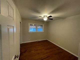 unfurnished bedroom with a closet, baseboards, dark wood finished floors, and a ceiling fan