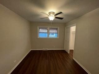 unfurnished bedroom with a closet, wood finished floors, a ceiling fan, and baseboards