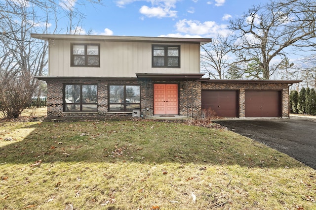 view of front of house with driveway, an attached garage, a front lawn, and brick siding