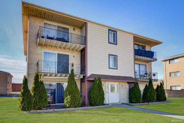 view of front of property with a front lawn and brick siding