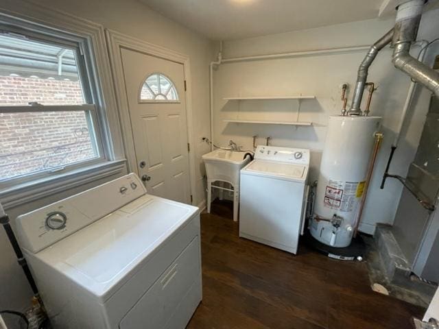 clothes washing area featuring gas water heater, laundry area, a sink, washer and dryer, and dark wood-style floors