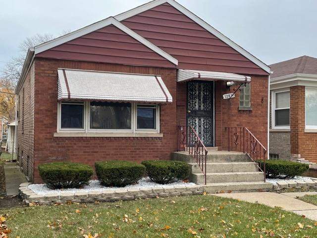 bungalow featuring brick siding