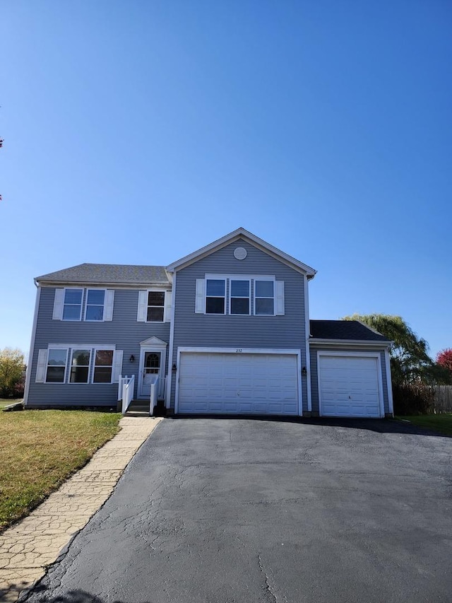 view of front of home with driveway, a front lawn, and an attached garage