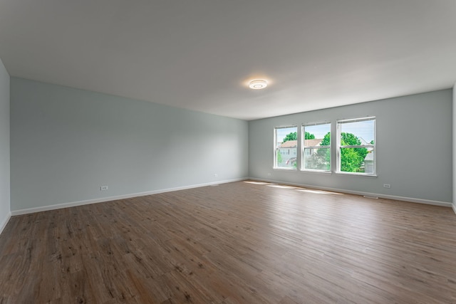 spare room with dark wood finished floors and baseboards